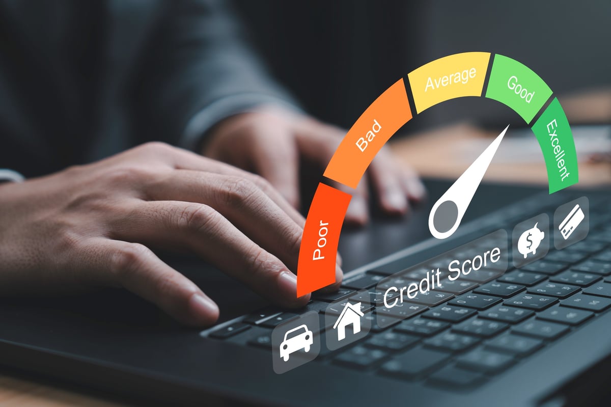 Laptop showing credit score gauge from poor to excellent
